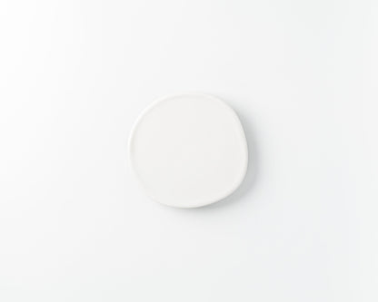 Minimalist handmade irregular white ceramic plate on a white background