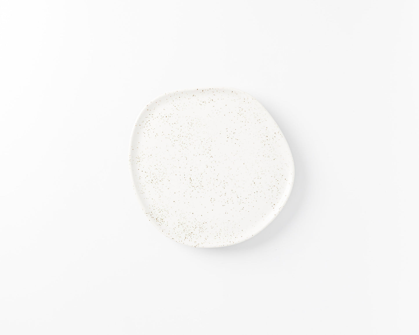 White ceramic plate with irregular shape and brown speckled pattern on white background