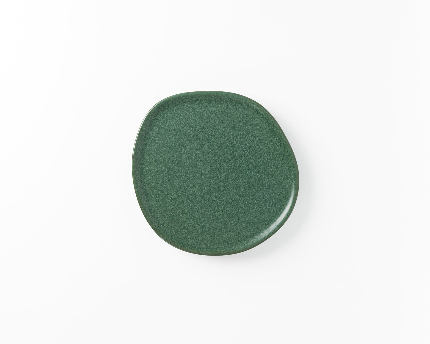 Green ceramic plate with irregular rounded shape on white background