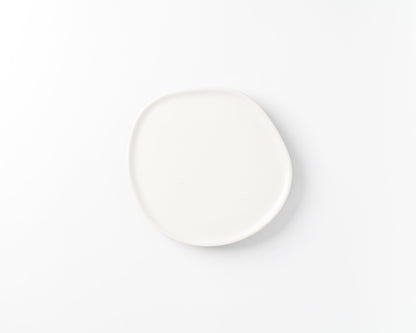 White ceramic plate with organic, irregular round shape on white background