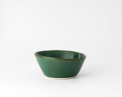 Green ceramic bowl with a smooth curved design on a white background