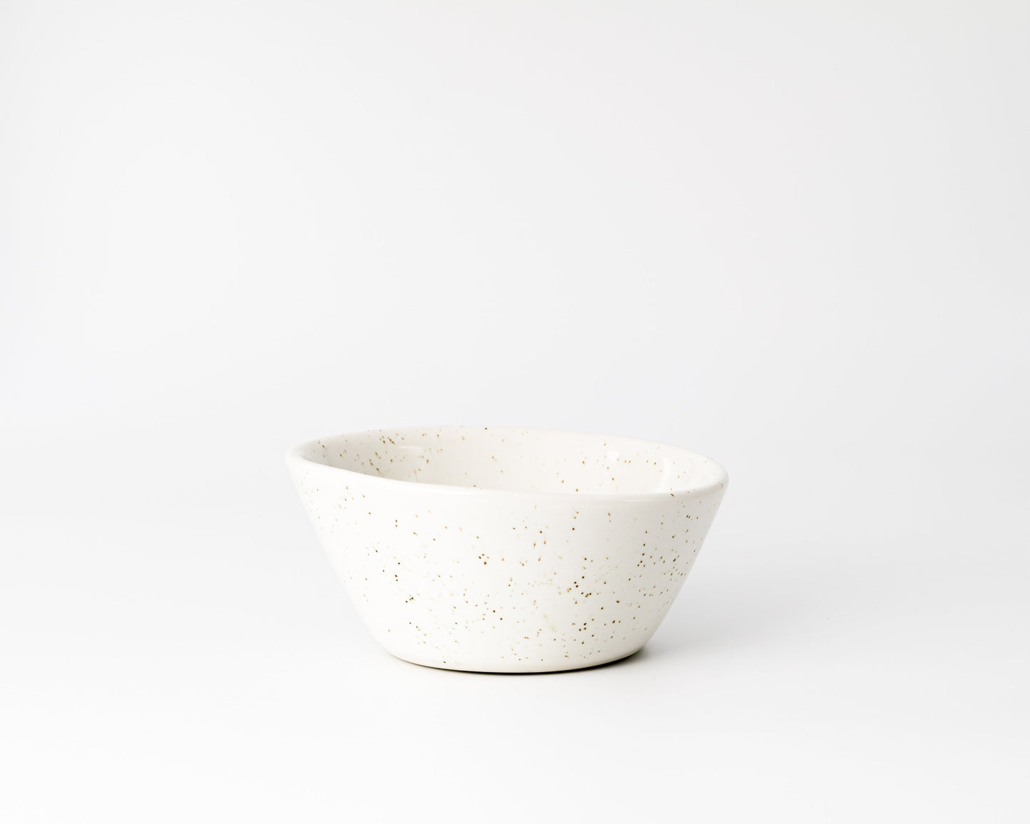 White ceramic bowl with brown speckled pattern on a white background