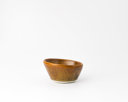 Handcrafted small brown ceramic bowl with a textured glaze on white background