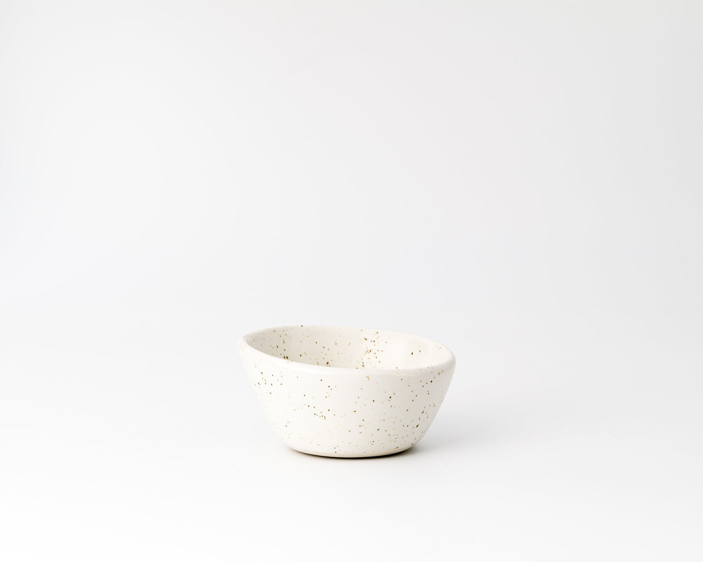 Small white speckled ceramic bowl on white background