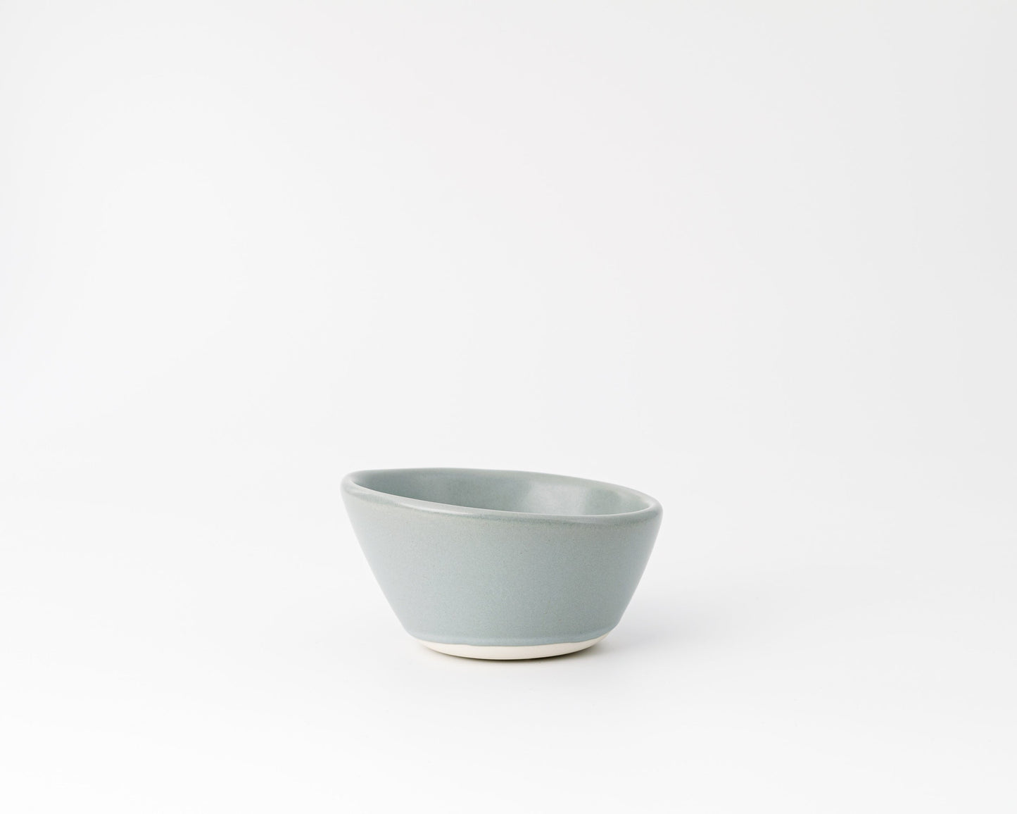 Minimalist light blue ceramic bowl with matte finish on white background