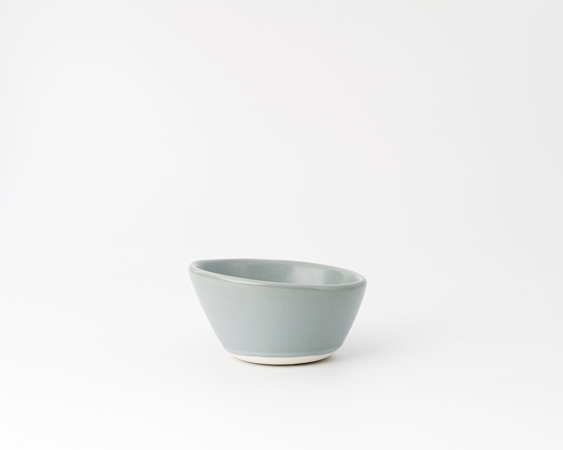 Minimalist light blue ceramic bowl with matte finish on white background