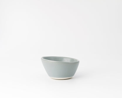 Minimalist light blue ceramic bowl with matte finish on white background