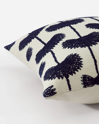 Angled corner detail of palm leaf embroidered throw pillow navy off white variant showing raised navy blue botanical embroidery stitch texture and linen weave on off white ground