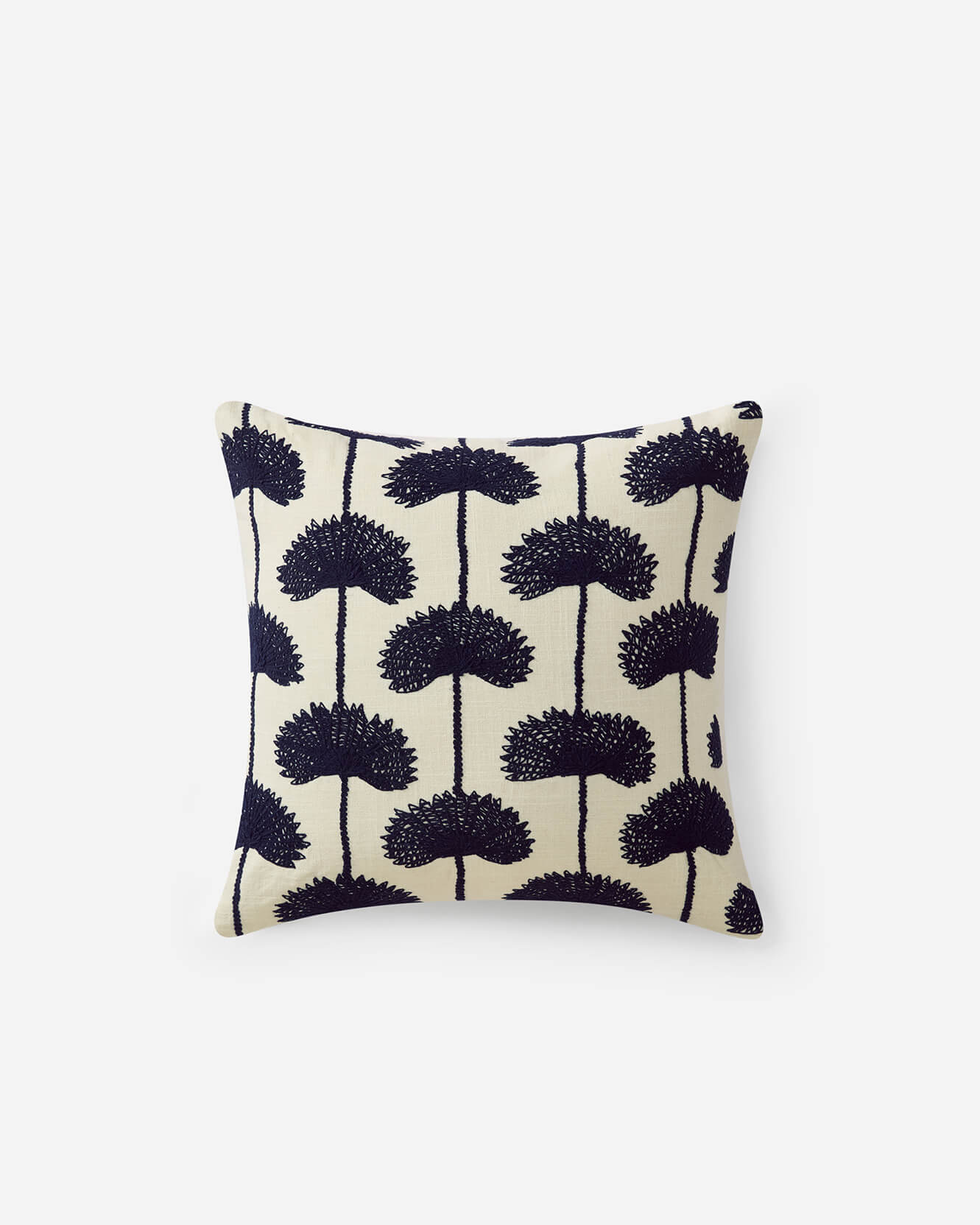 Off white throw pillow with navy blue embroidered palm leaf botanical repeat pattern on white background