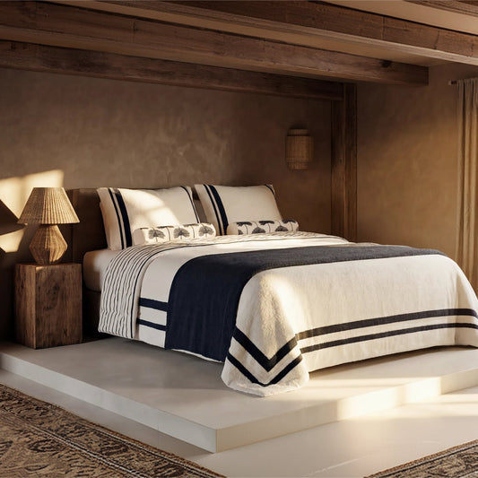 Amarena Snug Striped Comforter styled on bed in warm bedroom setting midnight navy stripes 