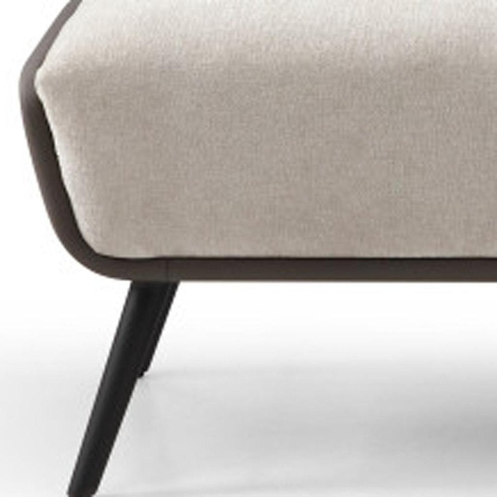Close-up of beige upholstered bench seat with dark gray vegan leather trim and black powder-coated steel leg detail