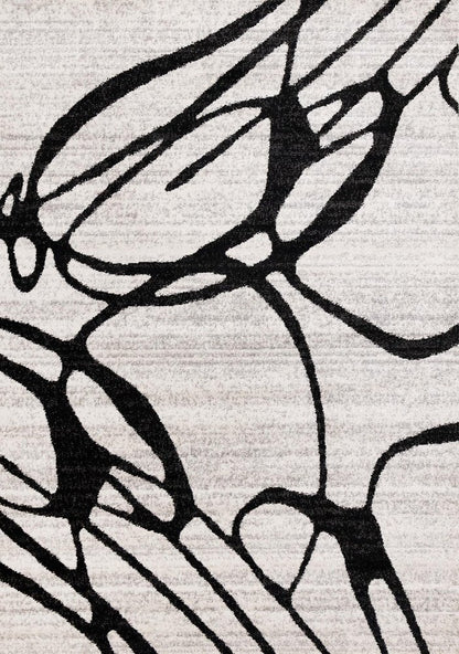 Black and gray abstract area rug close-up showing bold organic line pattern on a light ivory flat pile surface