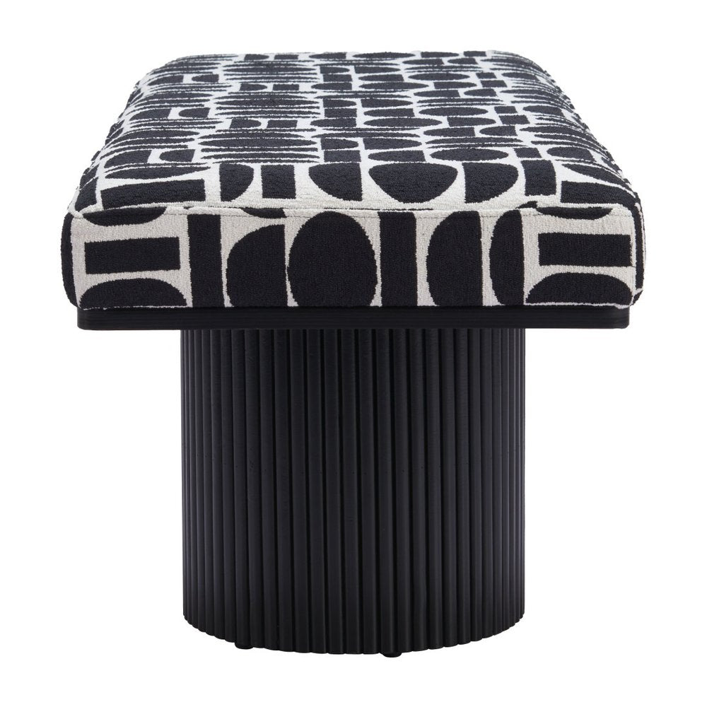 Front view of black and white geometric upholstered bench seat resting on single ribbed black cylindrical pedestal base on white background