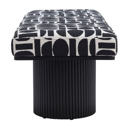 Front view of black and white geometric upholstered bench seat resting on single ribbed black cylindrical pedestal base on white background