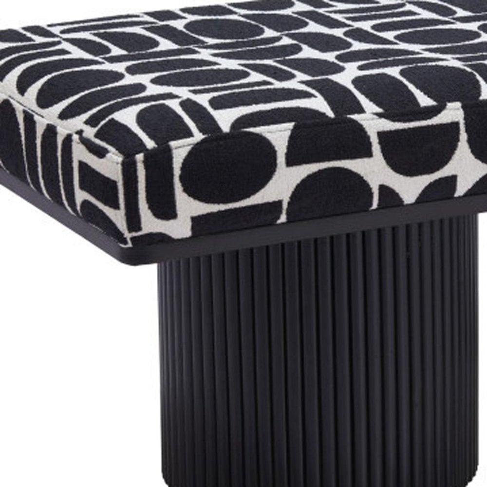 Close-up of black and white geometric patterned bench seat with ribbed black cylindrical pedestal leg detail on white background