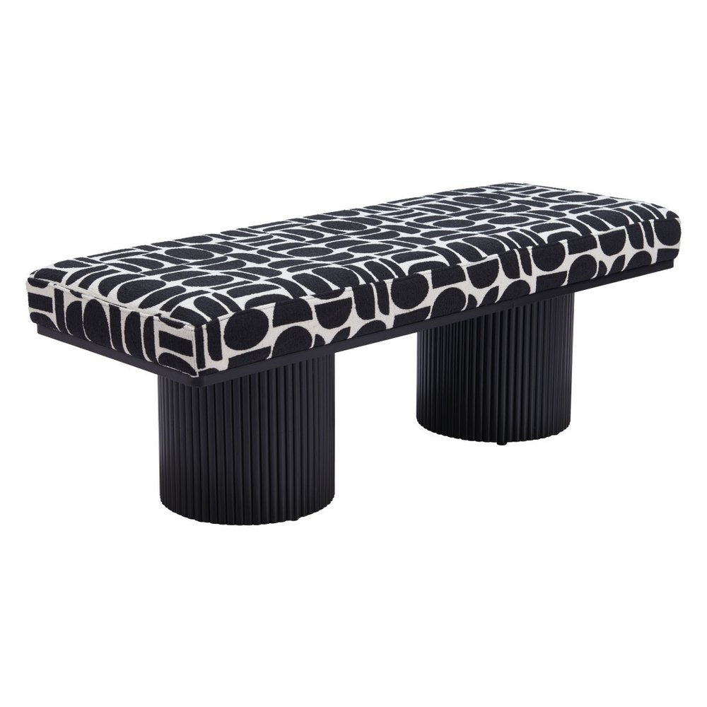 Angled view of black and white geometric upholstered bench with dual ribbed black cylindrical pedestal legs on white background