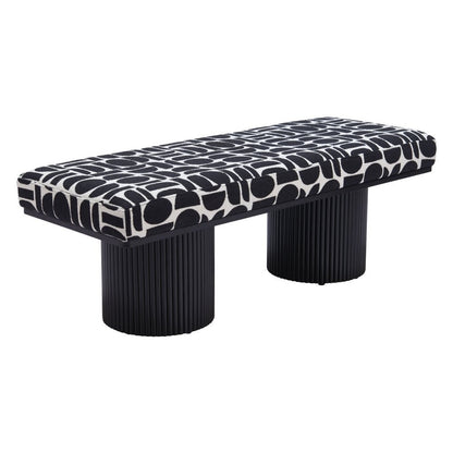 Angled view of black and white geometric upholstered bench with dual ribbed black cylindrical pedestal legs on white background