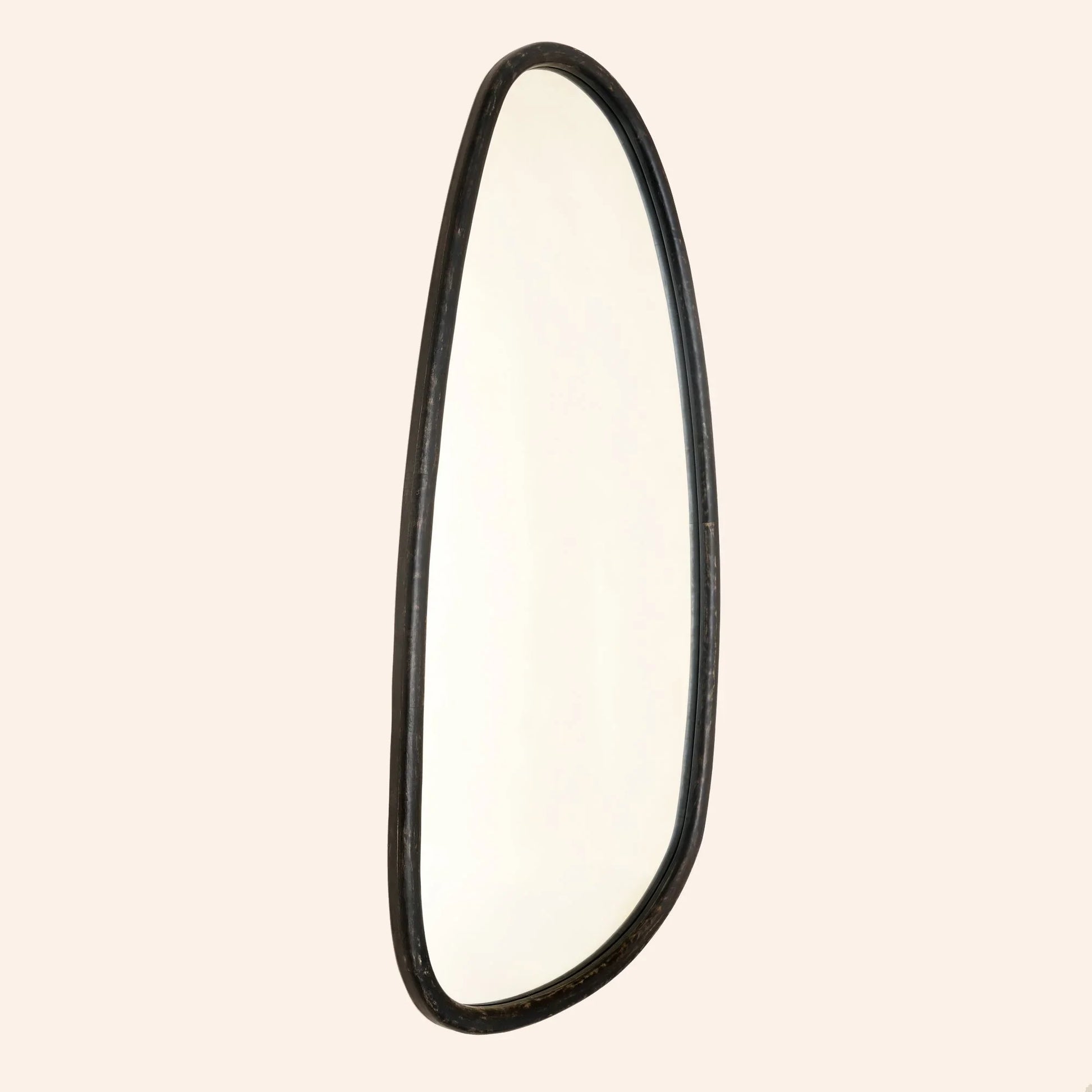 Side profile view of blackwash mango wood wall mirror showing irregular organic silhouette and slim frame depth against neutral background

