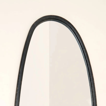 Close-up of blackwash mango wood wall mirror top arch showing handcrafted frame detail and smooth curved silhouette against neutral wall

