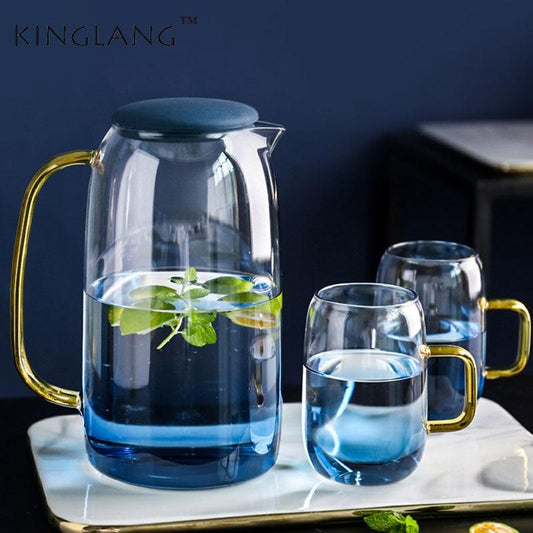 Blue carafe with gold handle and matching blue glass cups with mint leaves on marble tray