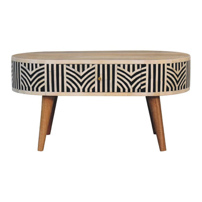 Oval bone inlay coffee table with black, bone, and oak chevron pattern, center drawer, tapered wood legs on a white background