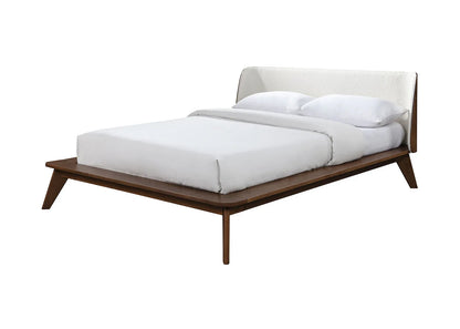 ​Profile view of a boucle platform bed frame highlighting the rich walnut wood grain finish and tapered angled accent leg