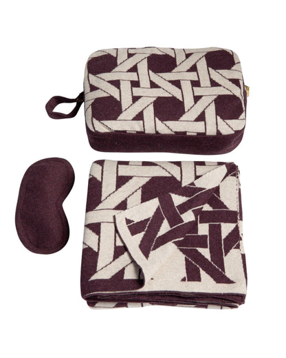Burgundy organic cotton travel blanket set with geometric pattern including folded blanket eye mask and compact pouch