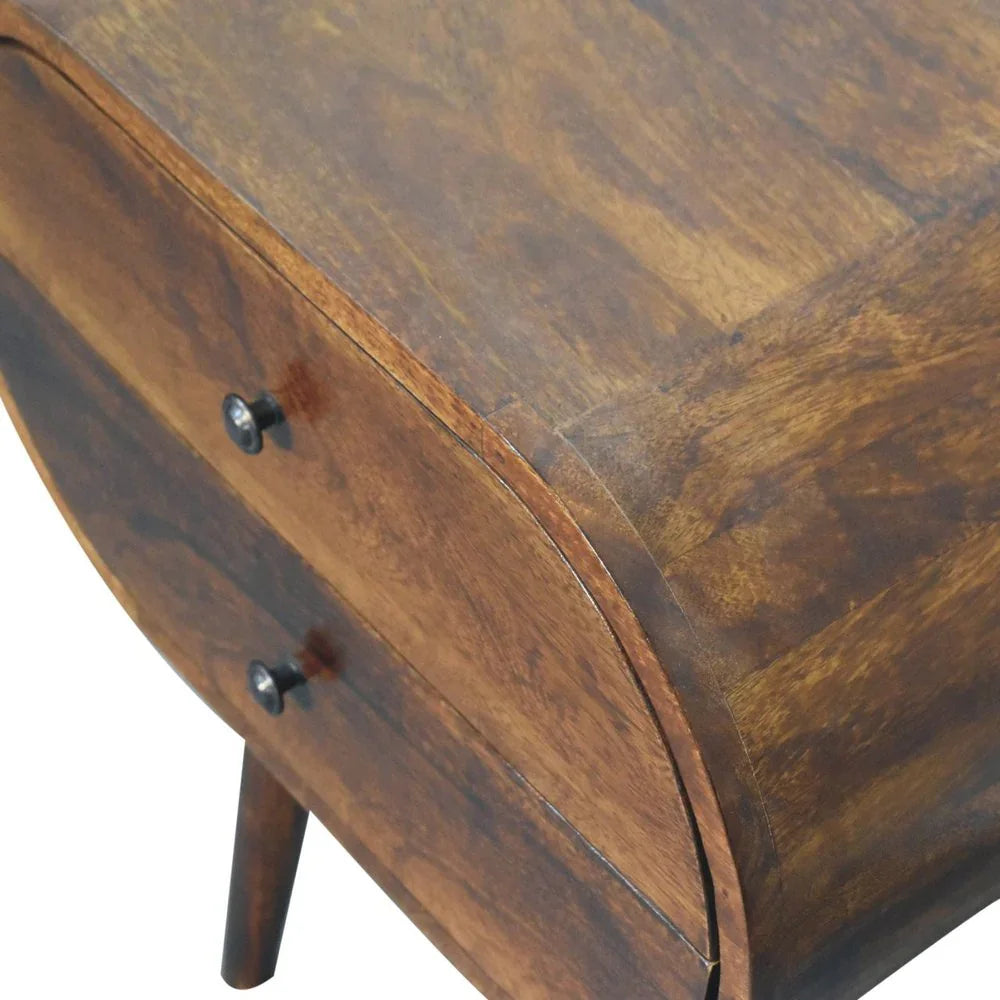 Top-angle detail of chestnut oval mango wood nightstand showing wood grain surface two drawers and tapered legs