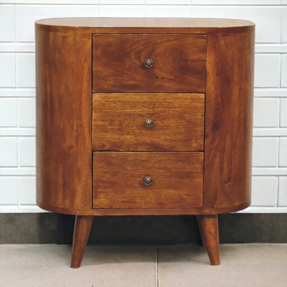 Chestnut solid wood compact cabinet styled against white tile wall showing three drawers silver knobs and Nordic splayed legs