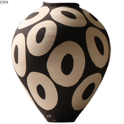 Front view of an Aurelia geometric decorative vase with light circular patterns on a dark rounded body, a narrow opening, and a tapered base against a white background.