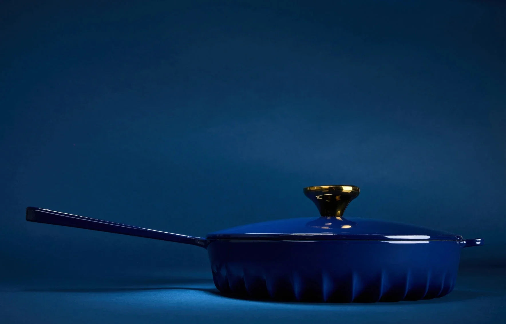 Side profile of the Oxford Blue FIREUP skillet highlighting the thin fin design base and hanging hole handle.