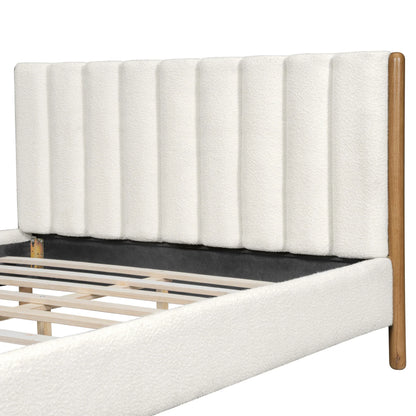 Close-up of white bouclé vertical panel headboard texture and plush padding detail with natural rubberwood leg on white studio background

