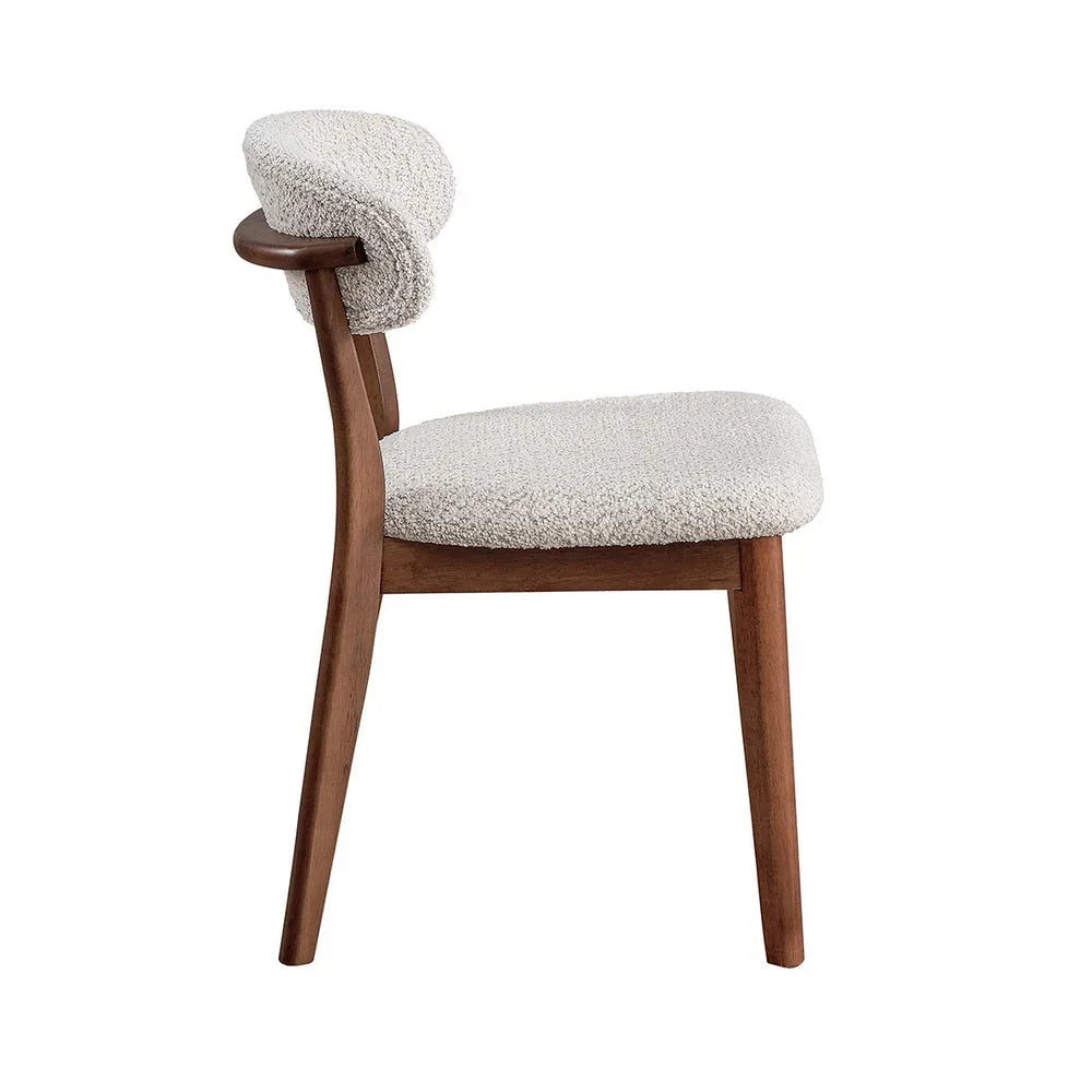 Cherry Scandinavian dining chair with bouclé upholstered seat and curved backrest shown from side on white studio background

