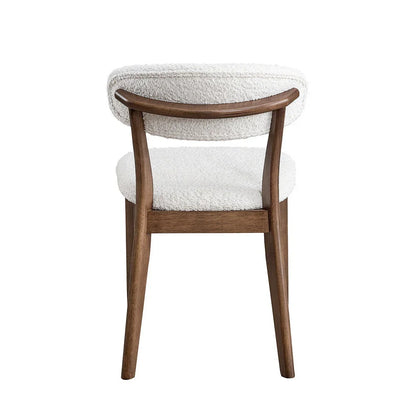Walnut Scandinavian dining chair with bouclé upholstered backrest and curved solid wood frame shown from rear on white studio background

