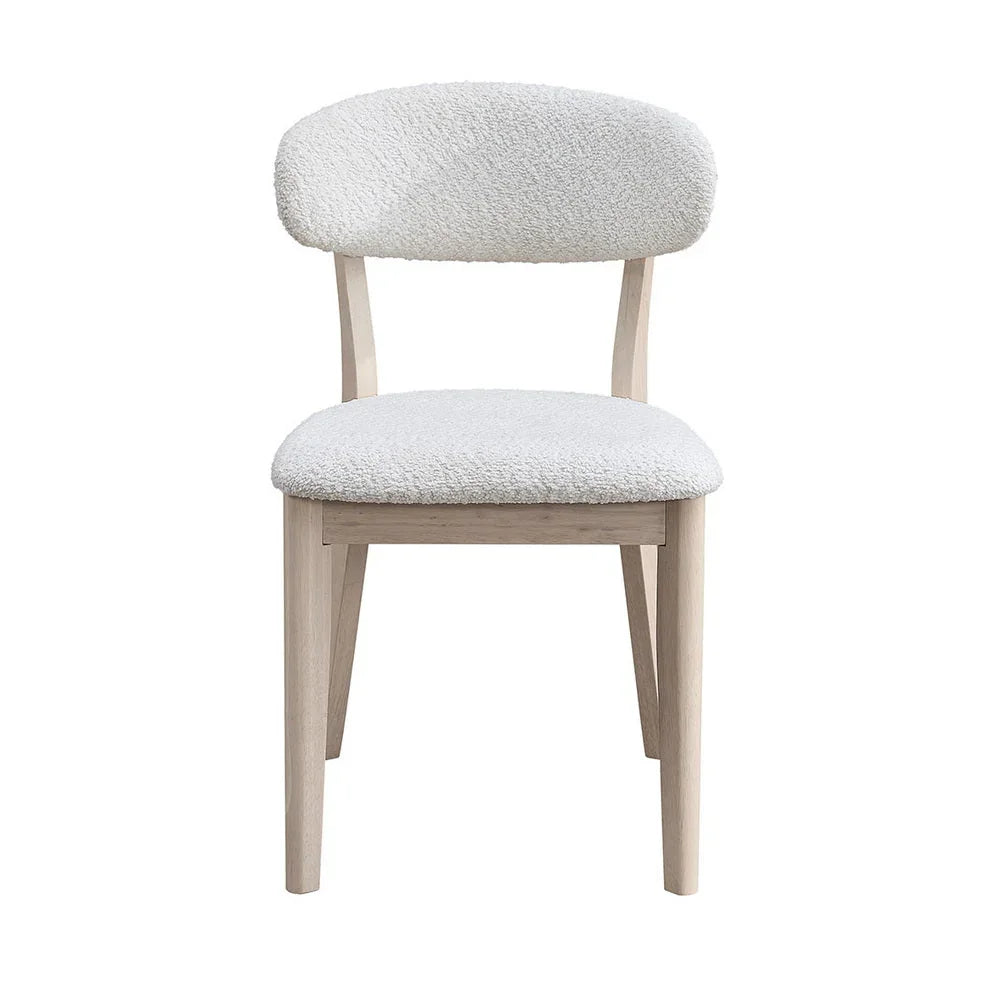 White-washed Scandinavian dining chair with bouclé upholstered seat and curved backrest shown from front on white studio background

