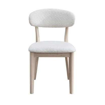 White-washed Scandinavian dining chair with bouclé upholstered seat and curved backrest shown from front on white studio background

