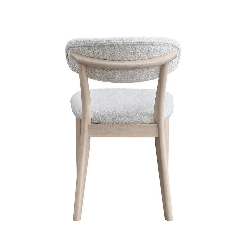 White-washed Scandinavian dining chair with bouclé upholstered backrest and curved solid wood frame shown from rear on white studio background

