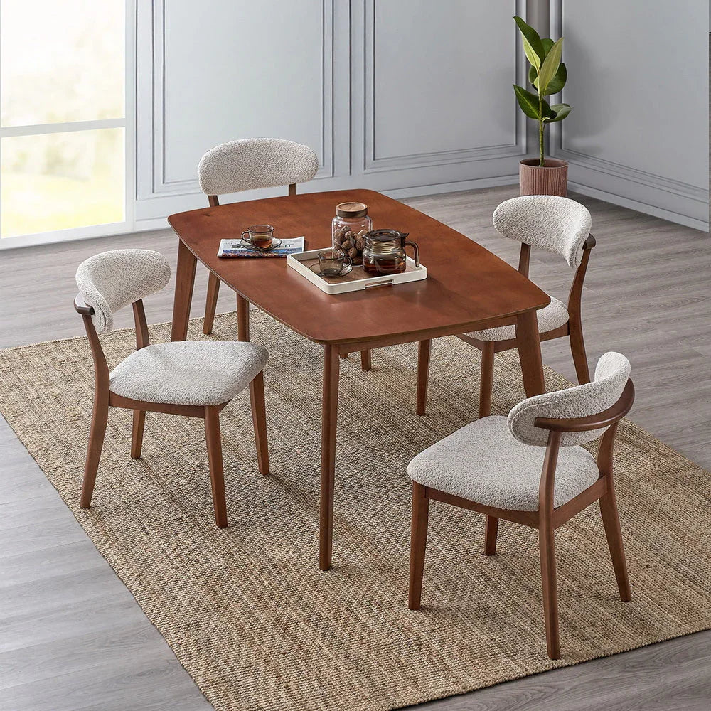 Cherry Scandinavian wood dining set with four bouclé upholstered chairs styled in a modern dining room with jute rug wood floors and indoor plant

