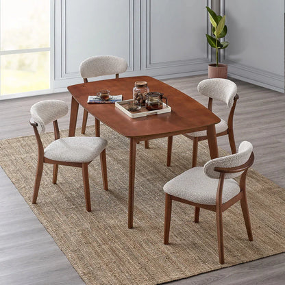 Cherry Scandinavian wood dining set with four bouclé upholstered chairs styled in a modern dining room with jute rug wood floors and indoor plant

