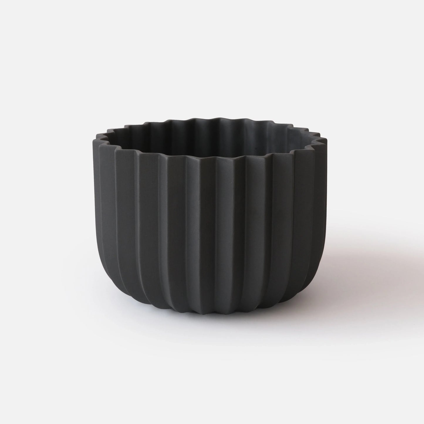Black Wrap Planter 9 inch large size empty on white studio background showing sculptural vertical ridge detail

