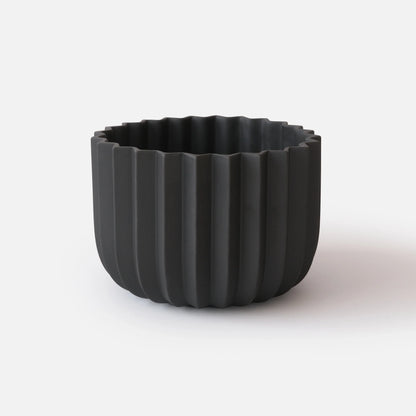 Black Wrap Planter 9 inch large size empty on white studio background showing sculptural vertical ridge detail

