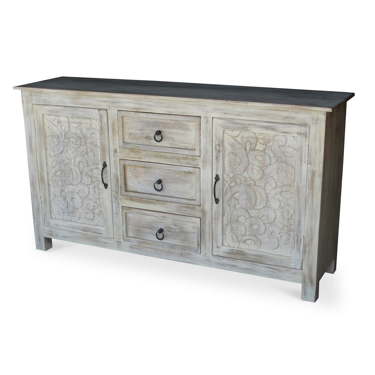 Hand carved antique sideboard angled view showing two floral carved doors three center drawers with iron ring pulls dark top surface and white antique distressed reclaimed acacia wood finish on white background