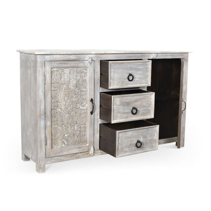 Hand carved antique sideboard angled view with all three drawers open showing interior depth floral carved left door panel iron ring drawer pulls and white antique reclaimed wood finish on white background