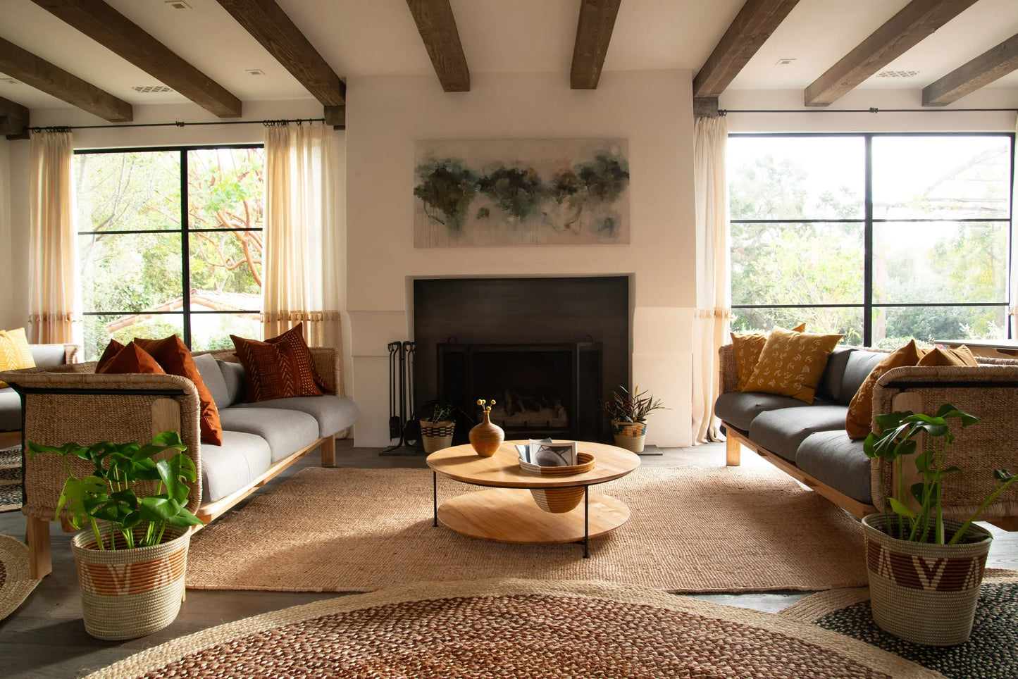 Lifestyle living room with handwoven rectangular sisal rug anchoring seating area under exposed wood beam ceiling with natural light