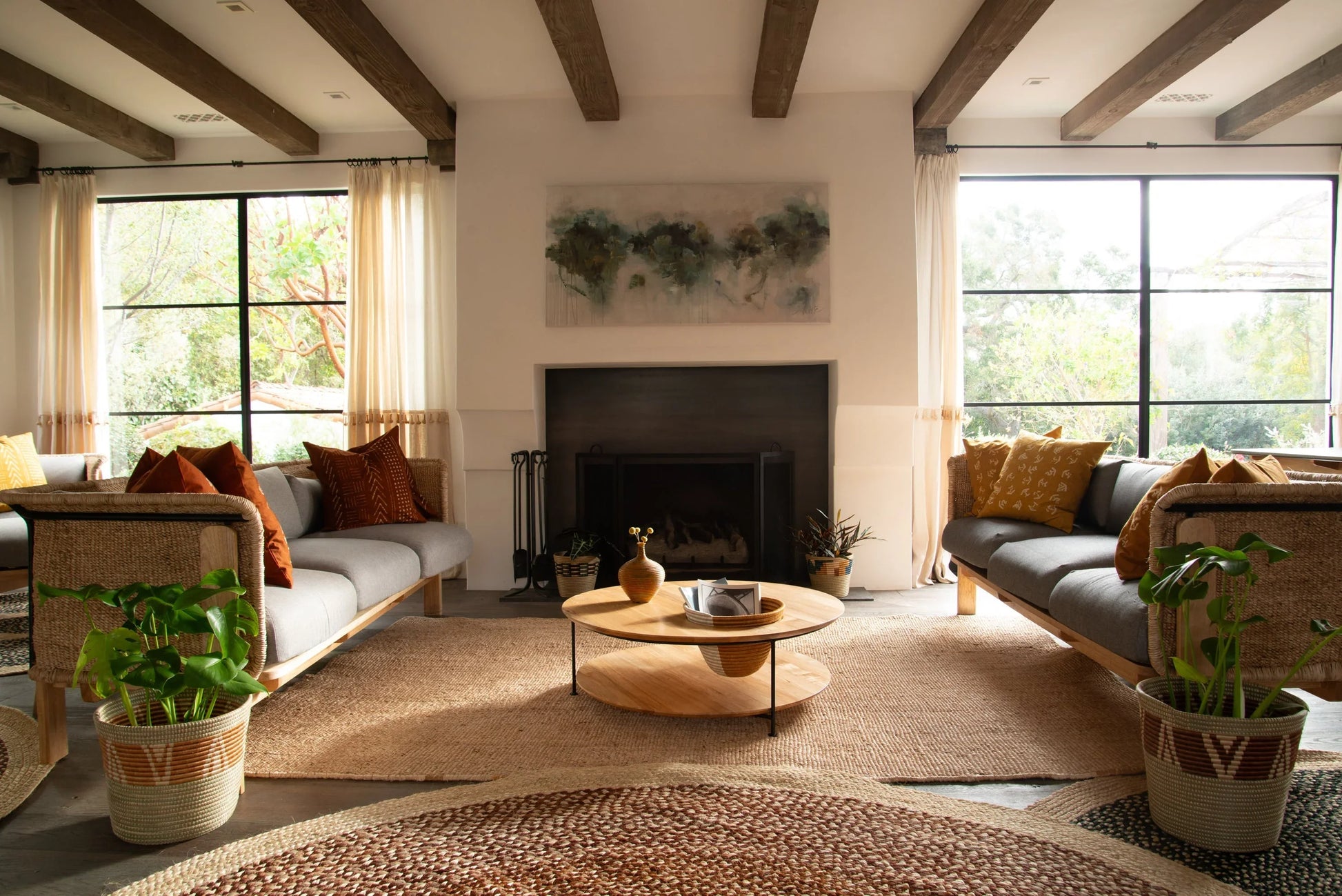 Lifestyle living room with handwoven rectangular sisal rug anchoring seating area under exposed wood beam ceiling with natural light