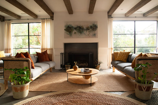 Lifestyle living room with handwoven rectangular sisal rug anchoring seating area under exposed wood beam ceiling with natural light