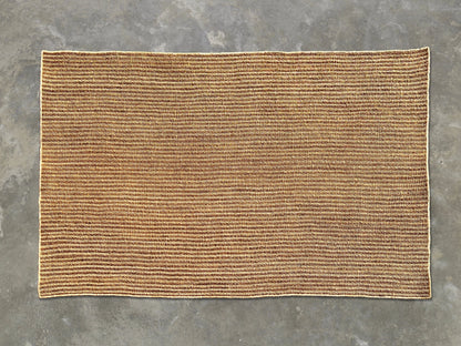 Full flat lay of handwoven rectangular sisal rug tea variant showing golden amber russet weave cream binding and full dimensions