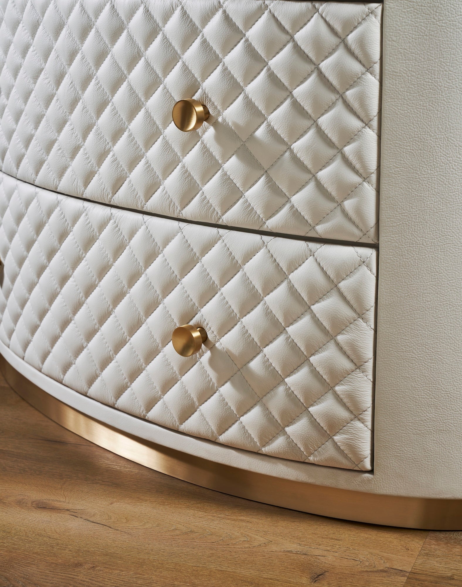 Harvard Quilted Three-Drawer Leather Chest white diamond-quilted leather texture brass knobs gold base close-up curved silhouette hardwood floor