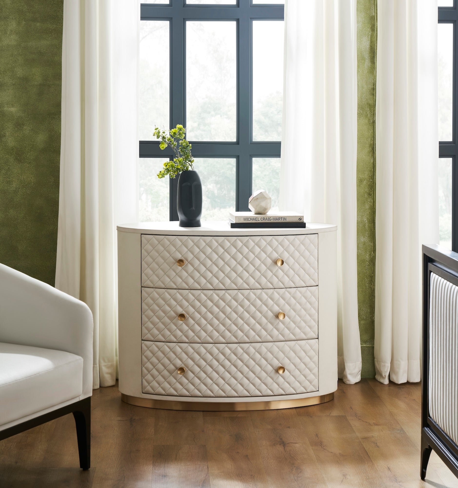 Harvard Quilted Three-Drawer Leather Chest white oval styled bedroom setting brass knobs gold base black vase greenery books window sheer curtains hardwood floor