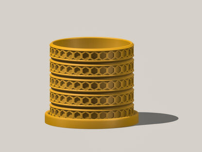 Orion hexagonal plant pot in Mustard, front view showing geometric lattice design, gray background